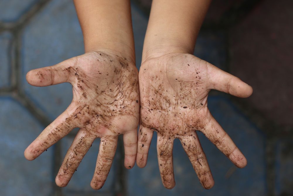 dirty hands with compost on