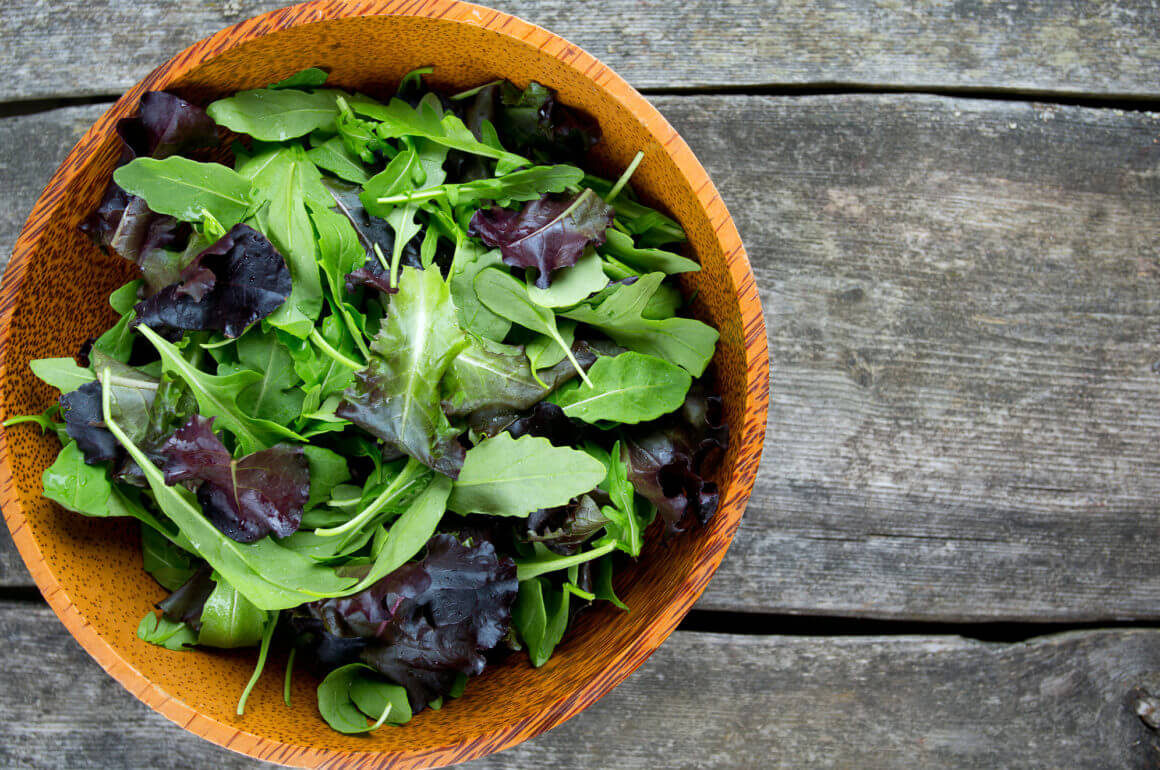 fresh green salad mix in a wooden bowl