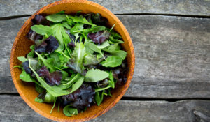 fresh green salad mix in a wooden bowl
