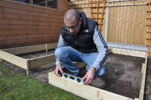 check the raised bed is level using a spirit level