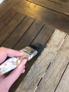 apply furniture wood stain to wooden garden furniture using a brush