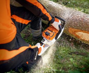 cordless MSA 300 chainsaw cutting through a tree